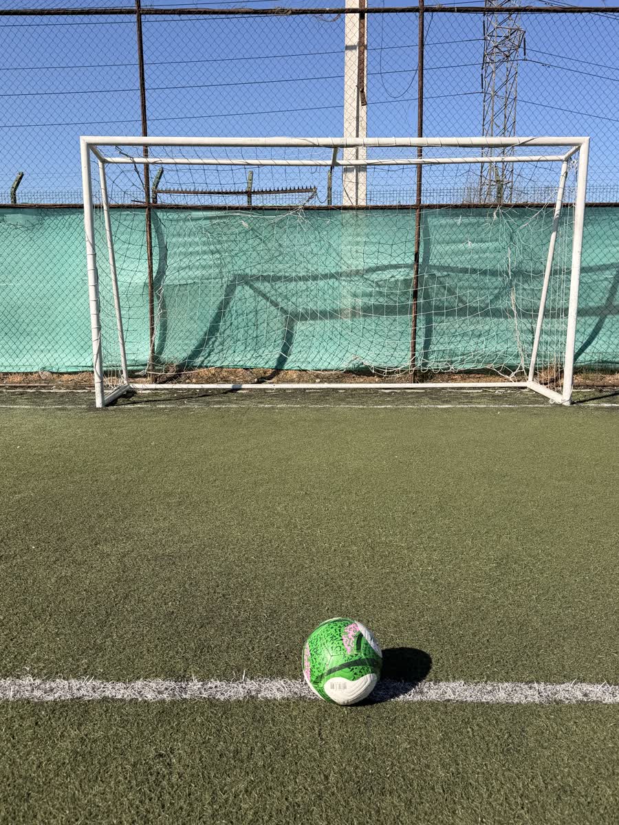 Arco de fútbol visto de frente con pelota lista para el disparo